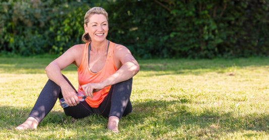Image of a woman sitting in the shade with a water bottle.